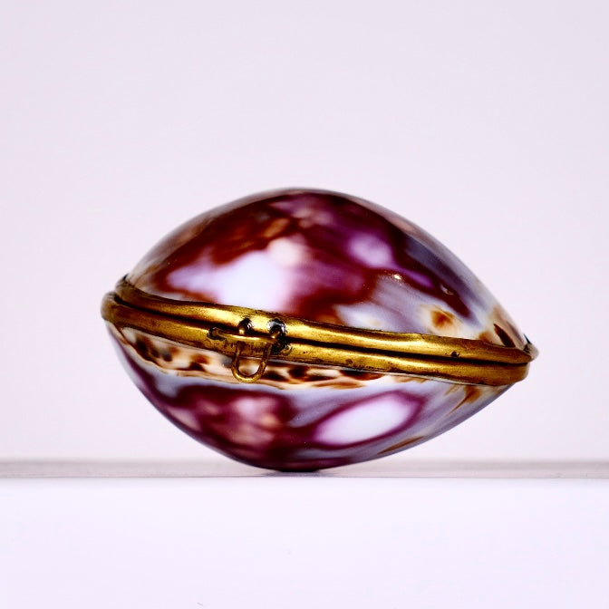 Shell-shaped jewelry box with gold accents on a white background