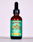 Bottle of Katydid Hill Poppy Dreams Elixir on a light purple background