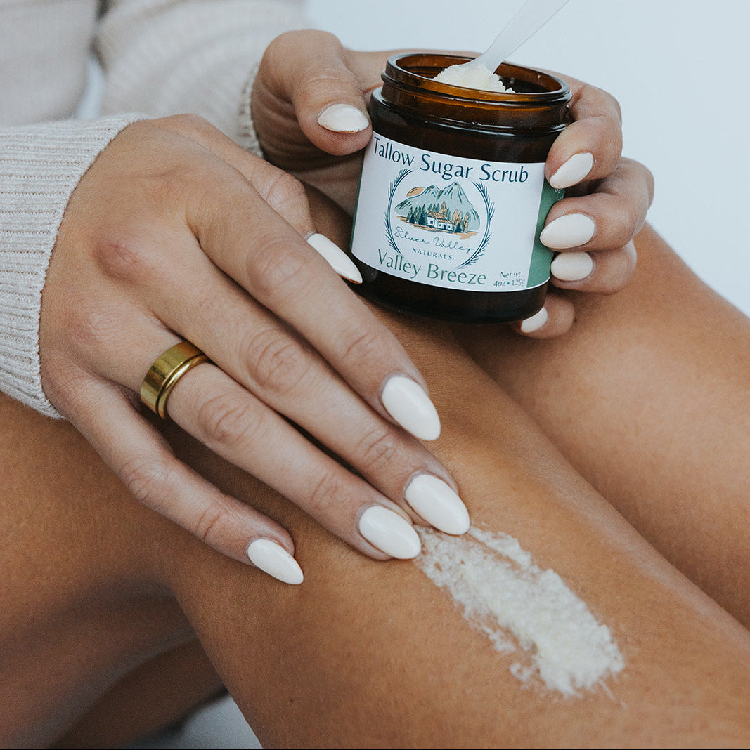 Person applying Silver Valley Natural Valley Breeze Sugar Scrub to their arm with a blurred background
