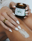 Person applying Silver Valley Natural Valley Breeze Sugar Scrub to their arm with a blurred background