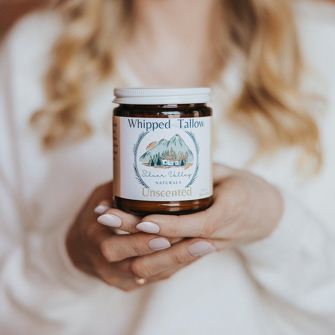 Person holding a jar of 'Whipped Talons' against a brick wall background