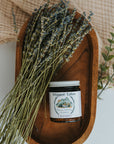 Wooden dish with a jar of 'Whipped Talloch' and lavender on a textured surface