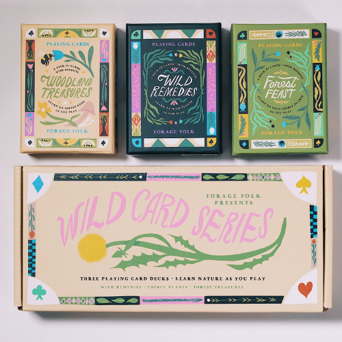 Three playing card boxes with colorful botancial designs and nature educational information